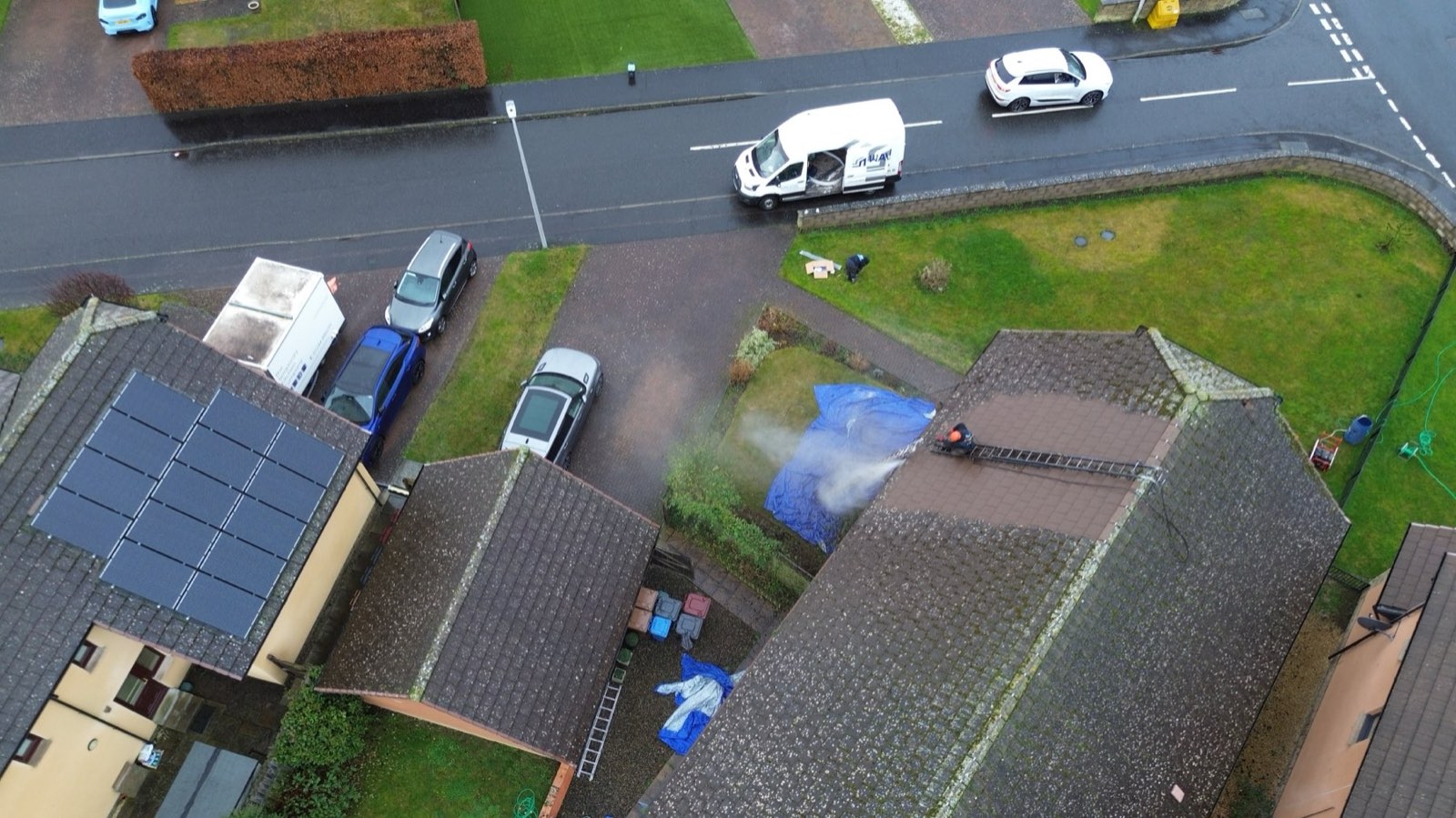 Aerial view of a WaveTech roof and exterior clean in progress, with the company van on the street