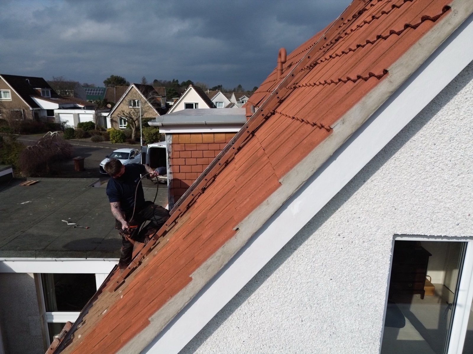 WaveTech roofer working on a coating under dramatic Scottish skies