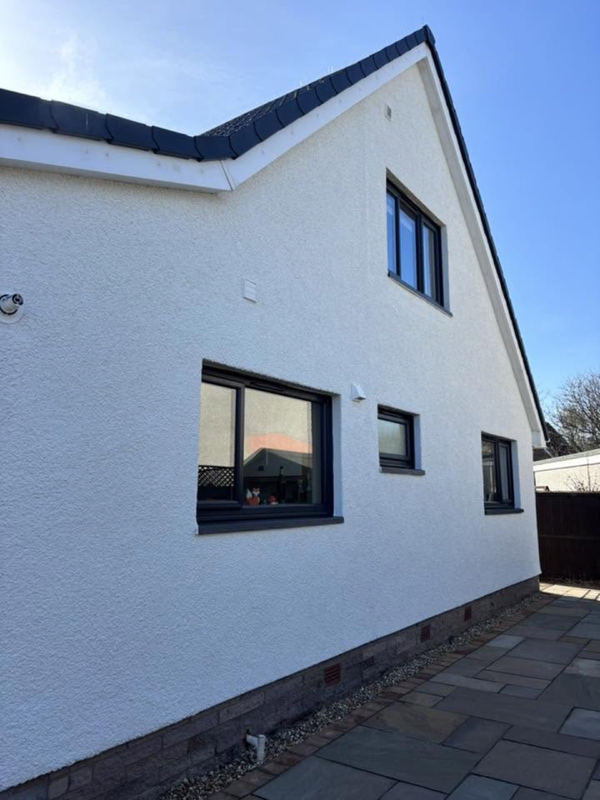 A freshly coated white render home with smart black trim