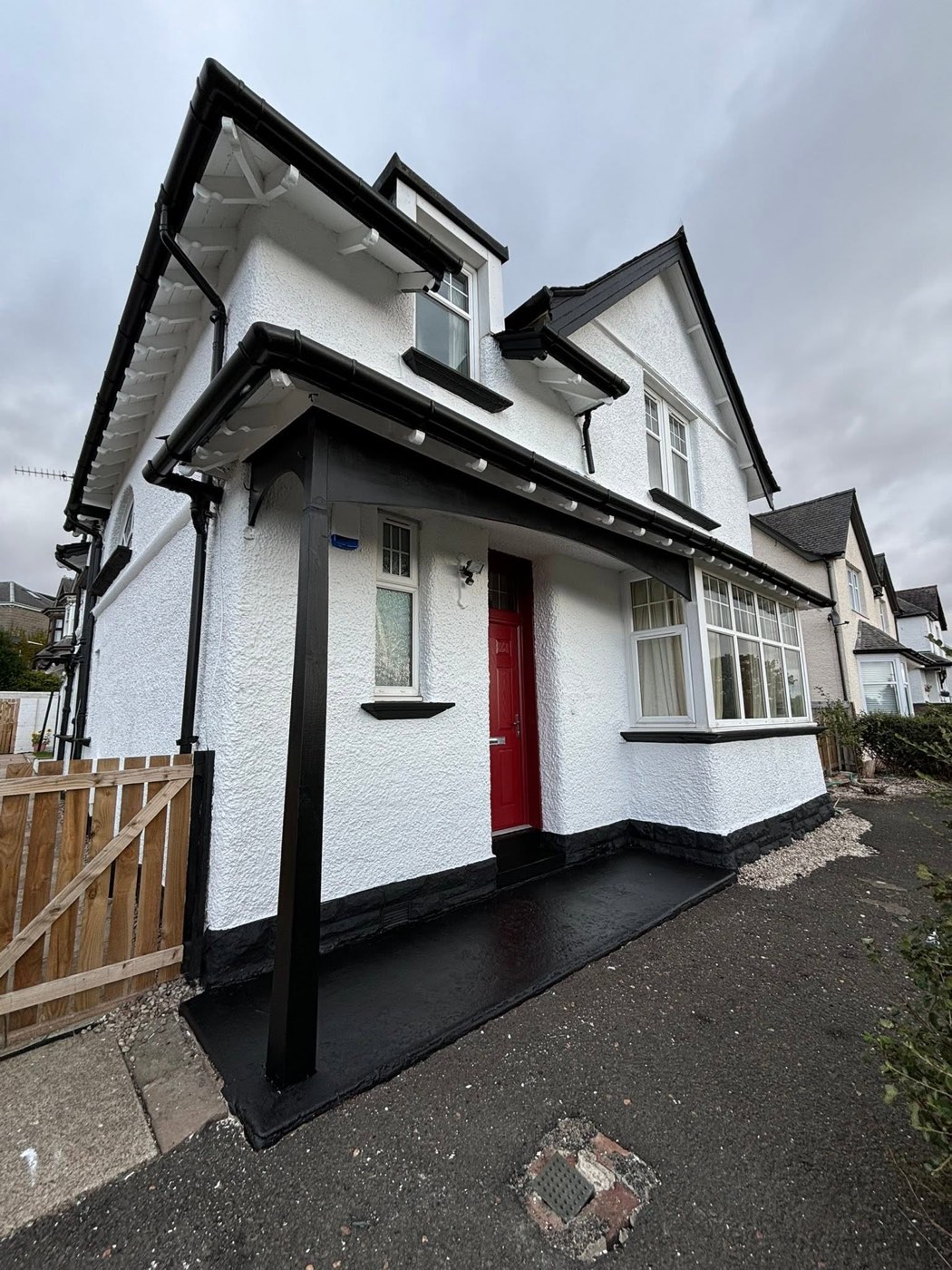 A freshly coated white house wall with crisp black detailing